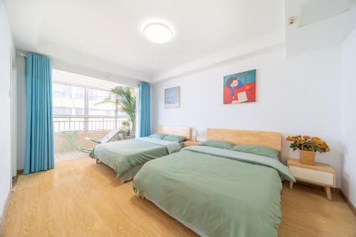 two beds in a bedroom with blue curtains at Cloud & Sea Boutique Apartment in Rizhao