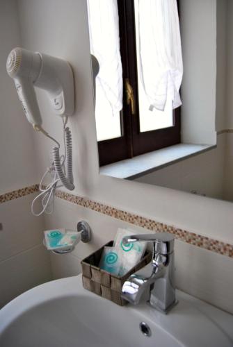 a bathroom sink with a hair dryer and a mirror at Il Quadrifoglio Room& Suite in Palermo
