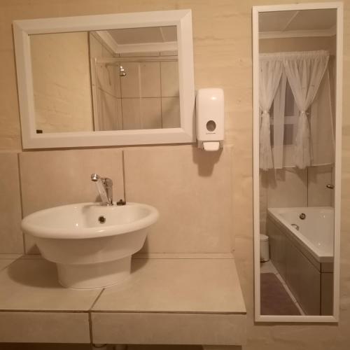 a white bathroom with a sink and a mirror at BoHo in Velddrif