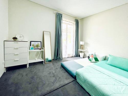 a bedroom with a bed and a dresser and a window at Larisa Homestay Syariah in Padalarang