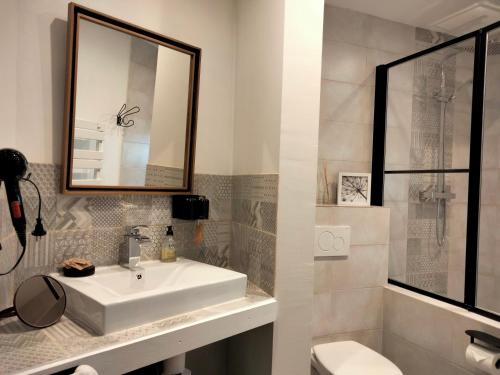 uma casa de banho com um lavatório, um espelho e um WC. em A l'Ombre de la Dame em Cucuron