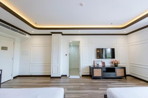 a large room with white walls and a hallway with a desk at Khách sạn Robin Gia Nghĩa in Gia Nghĩa