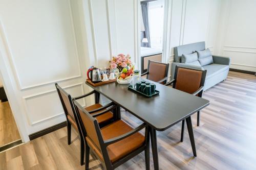 a dining room with a table and chairs and a couch at Khách sạn Robin Gia Nghĩa in Gia Nghĩa