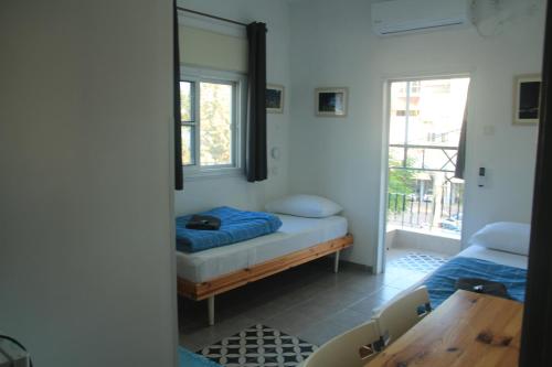 a room with a bed and a table and a mirror at David Hostel in Tiberias