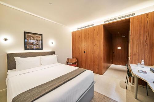 um quarto de hotel com uma cama e uma secretária em Wanderlust, The Unlimited Collection managed by The Ascott Limited em Singapura