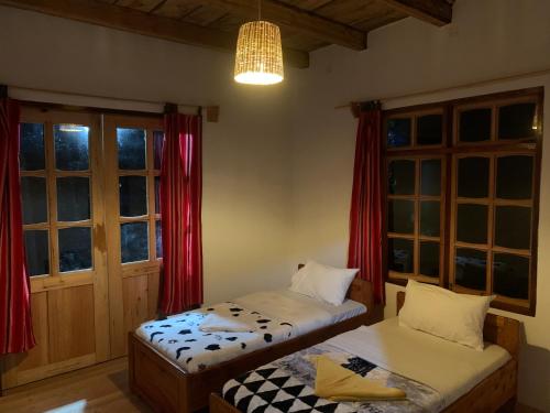 a room with two beds and a chandelier and windows at David Crater Homestay in Lushoto