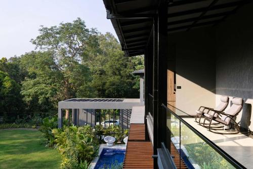 a house with a swimming pool on a balcony at StayVista at The Charcoal Villa Luxury Collection in Alibaug
