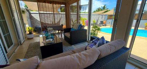 un soggiorno con divano e piscina di La Bohème a La Paix
