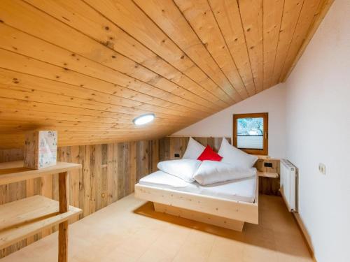 a bed in a room with a wooden ceiling at Charming holiday home in F genberg with lots of comfort in Fügenberg