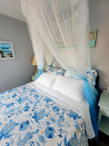 a bedroom with a blue and white bed with a canopy at Searenity, Waterside studio in the heart of Treasure Island, walk to beach in St Pete Beach