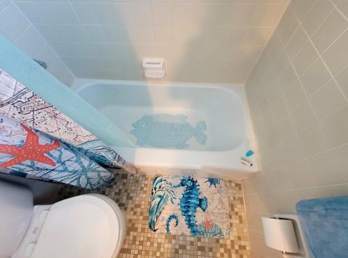 a bathroom with a bath tub with a fish in it at Searenity, Waterside studio in the heart of Treasure Island, walk to beach in St. Pete Beach