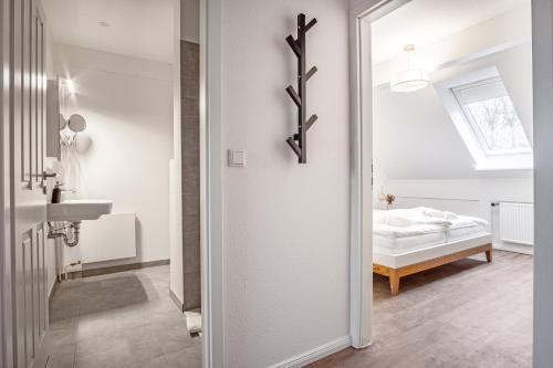 ein Bad mit einem Waschbecken und ein Bett in einem Zimmer in der Unterkunft Inselquartier-Pellworm in Pellworm