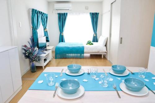 a dining room with a table with blue dishes on it at MishukuOnna201 in Onna