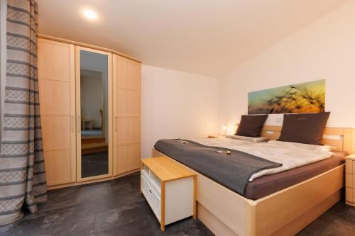 a bedroom with a large bed and a mirror at Urlaubsoase im Edertal in Bad Berleburg