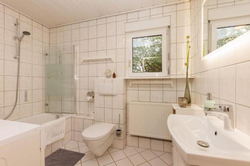 a white bathroom with a toilet and a sink at Urlaubsoase im Edertal in Bad Berleburg