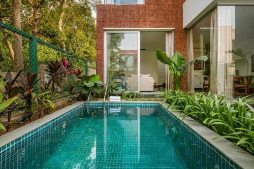 a swimming pool in a backyard with a house at La Avila by The Blue Kite - 2 BHK Villas near Morjim Beach & Thalassa with Private Pool, Kitchen, Balcony & Security in Siolim