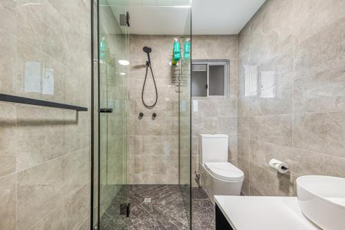 a bathroom with a shower and a toilet at Beachcomber Peregian Beach in Peregian Beach