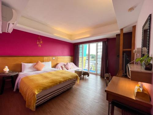 墾丁的住宿－澤信旅店，一间卧室设有一张大床和紫色的墙壁
