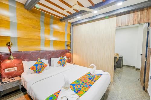 a bedroom with a white bed and a colorful wall at FabExpress Prime Middleton in Bhubaneshwar