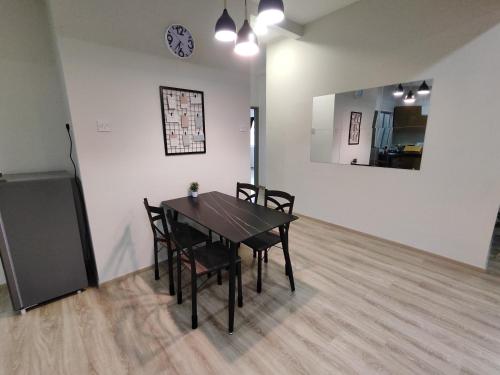 a dining room table with chairs and a clock on the wall at Family Apartment at The Quintet Cameron Highlands in Cameron Highlands
