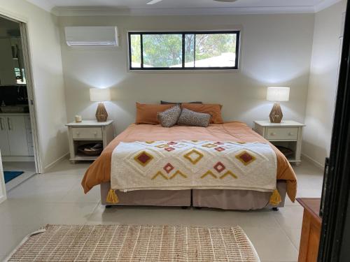 a bedroom with a large bed with a window at Sonnys Piece Of Paradise in Agnes Water