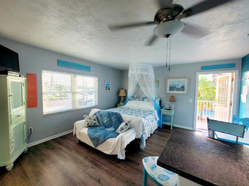 um quarto com uma cama e uma ventoinha de tecto em Searenity, Waterside studio in the heart of Treasure Island, walk to beach em St. Pete Beach