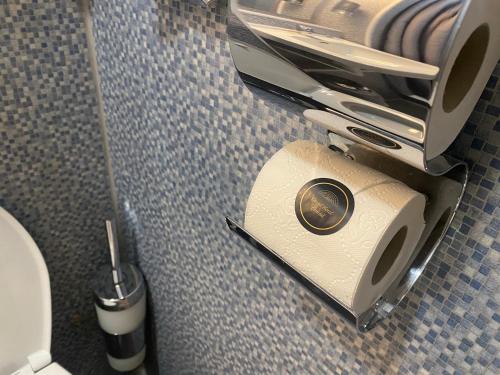 a small bathroom with a toilet and a toilet brush at Grand Hotel Central in Rotterdam