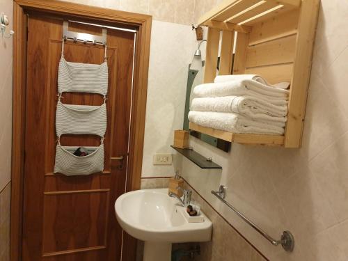 a bathroom with a sink and a toilet with towels at Appartamento La Carambola 110mq in Maglie