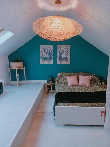 1 dormitorio con 1 cama grande y pared azul en Appartement ! Petit nid entre pistes et lacs!, en Saint-Laurent-en-Grandvaux