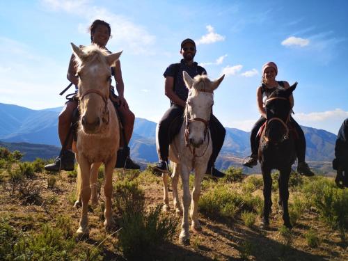a group of people riding horses on a hill at Casa Tumi Round Houses. 