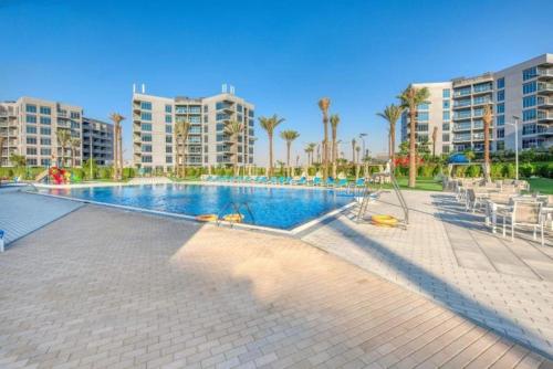 a large swimming pool with palm trees and buildings at a chilled place in Dubai