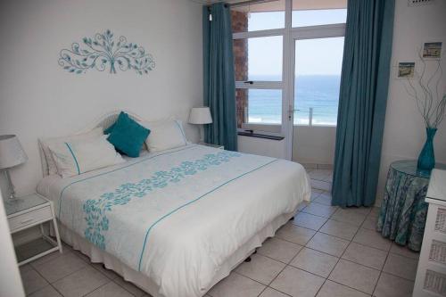 a bedroom with a bed with a view of the ocean at Sealodge 75 Umhlanga Durban in Durban