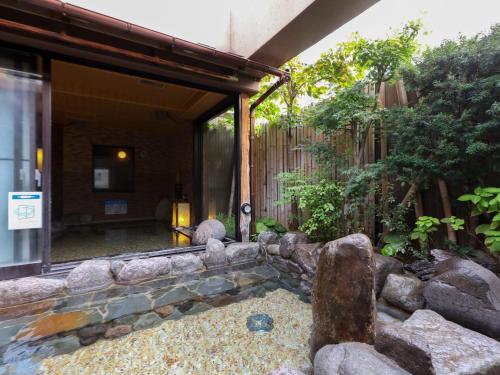 un jardin en pierre devant un bâtiment dans l'établissement Dormy Inn Takasaki, à Takasaki