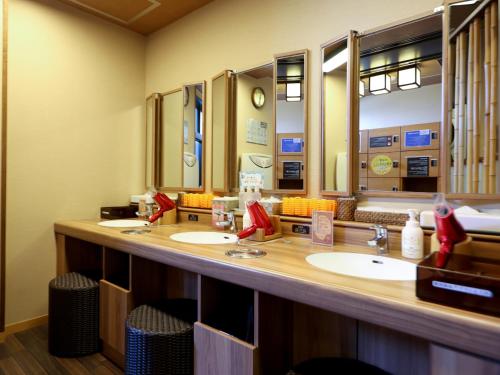 a bathroom with two sinks and two mirrors at Dormy Inn Takasaki in Takasaki