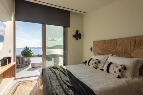 a bedroom with a large bed with a large window at Gaia and Thalatta Villas in Évyiros
