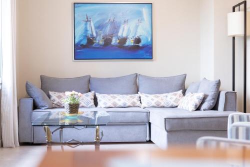 a living room with a couch with a painting on the wall at Amazing Modern Apartment with Sea View in Athens