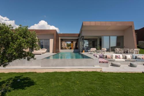 a villa with a swimming pool and a house at Gaia and Thalatta Villas in Évyiros