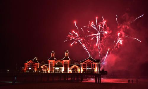 a house on the beach with fireworks behind it at Siggis Pension - Apartments in Ostseebad Sellin