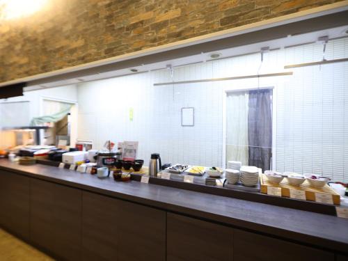 a kitchen with a counter with plates and bowls at Dormy Inn Takasaki in Takasaki