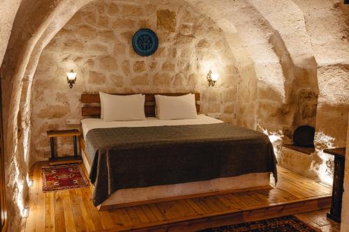 a bedroom with a bed in a stone room at Hanzade Cappadocia in Goreme