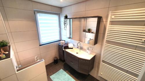 een badkamer met een wastafel en een spiegel bij Fewo Am Tiefen Weg in Karlstadt