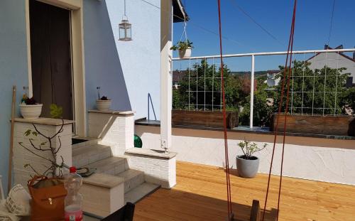 a balcony with potted plants and a large window at Fewo Am Tiefen Weg in Karlstadt