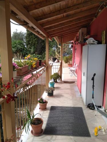 a porch with potted plants and a white refrigerator at Kostas Walkers Point in Dafnáta