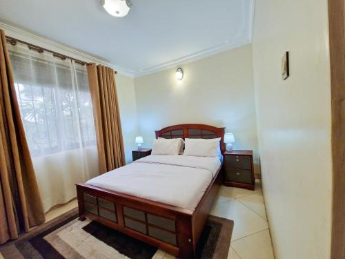 坎帕拉Eric Wilkins Apartments的一间卧室，里面有一张床和一扇窗户。