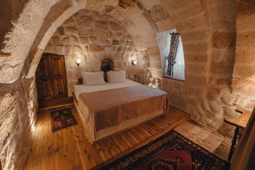 a bedroom with a bed in a stone room at Hanzade Cappadocia in Goreme