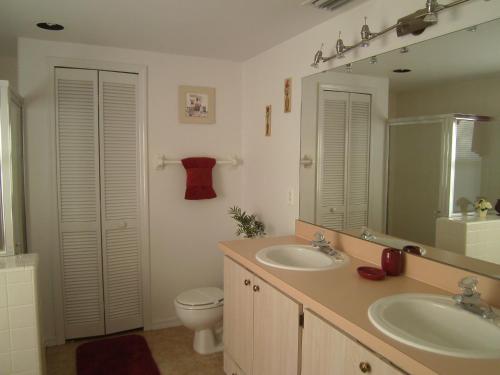 a bathroom with two sinks and a toilet and a mirror at 4 Bedroom Value Plus Home with Private Pool in Orlando