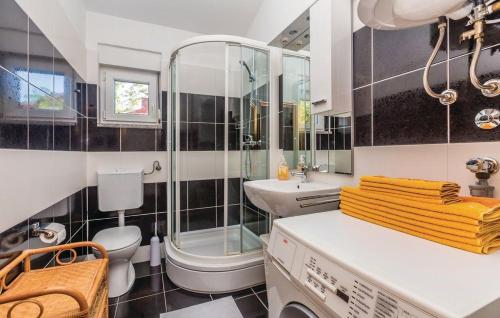 La salle de bains est pourvue de toilettes, d'un lavabo et d'une douche. dans l'établissement Apartmani Ivanković, à Karlobag