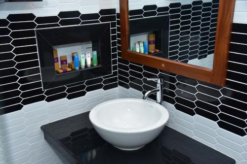 a bathroom with a white sink and a mirror at Eden Grand in Dambulla