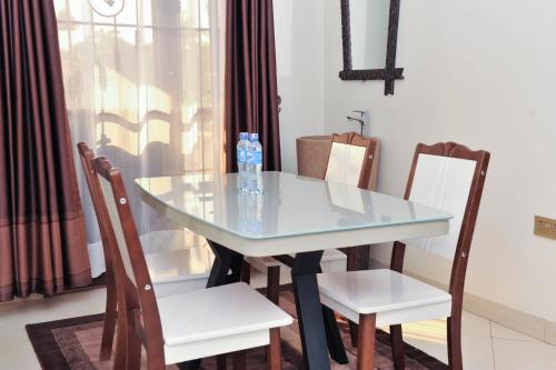 a dining room table with two chairs and a blue table at Eric Wilkins Apartments in Kampala