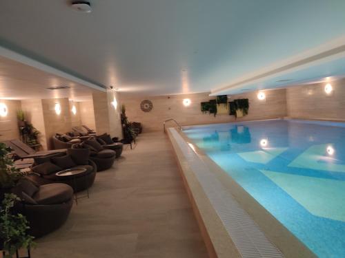 a large swimming pool in a hotel with lounge chairs at Azura Residence - new luxury apartment in Belgrade